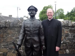 Rev Anderson next to the statue of St Quigg